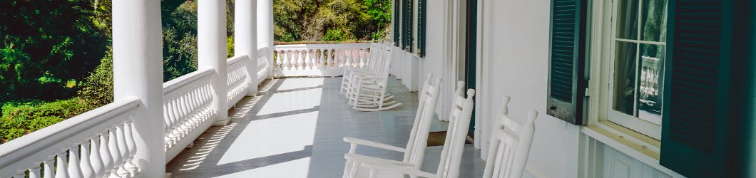 White front porch with columns, balustrades and rocking chairs